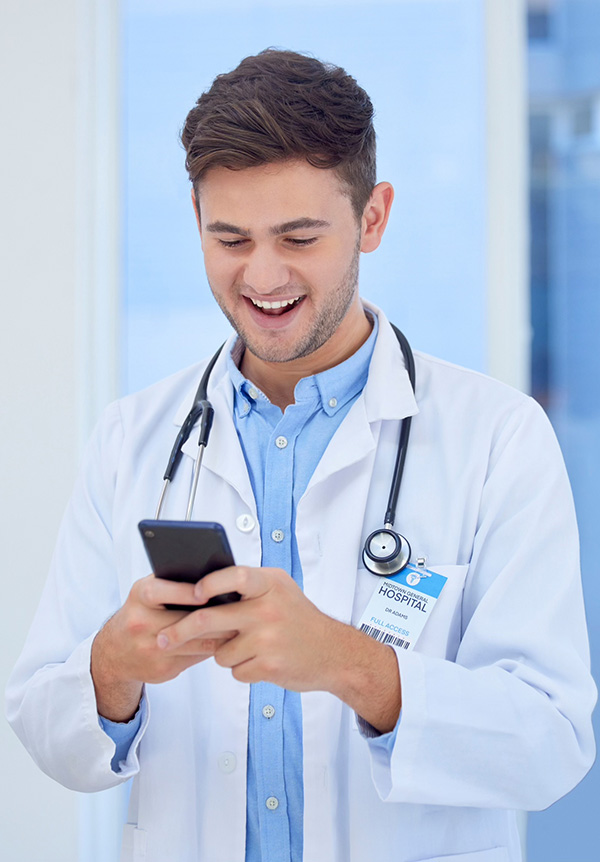 Doctor smiling while using a smartphone