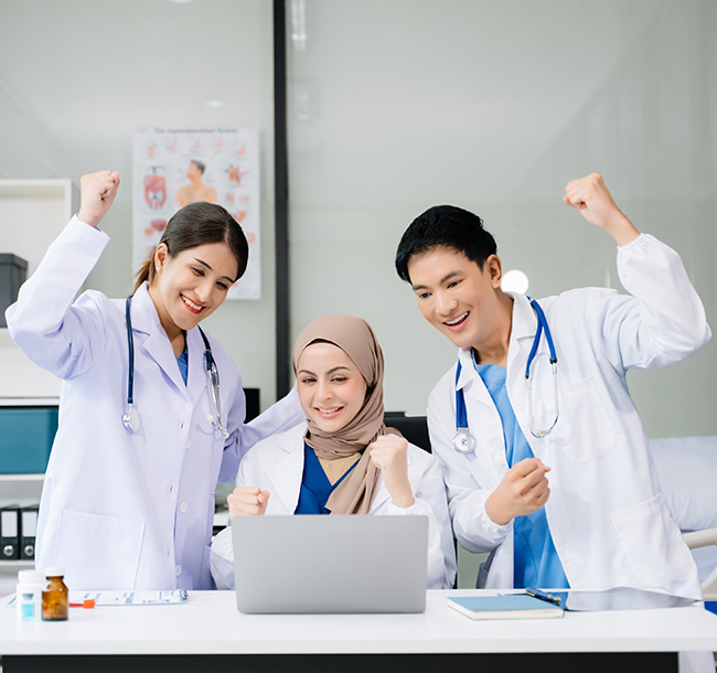 Medical team discussing information around a laptop